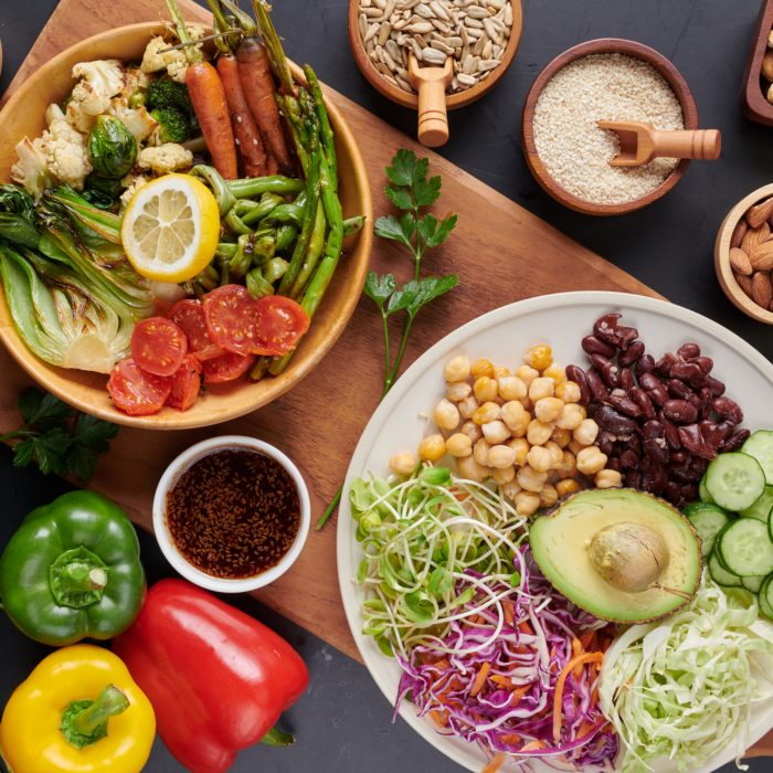 Vegan protein source. Buddha bowl dish, avocado, pepper, tomato, cucumber, red cabbage, chickpea, fresh lettuce salad and walnuts, nuts, beans, . Healthy vegetarian eating, super food. Top view.